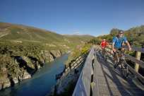 Couple crossing bridge on bikes