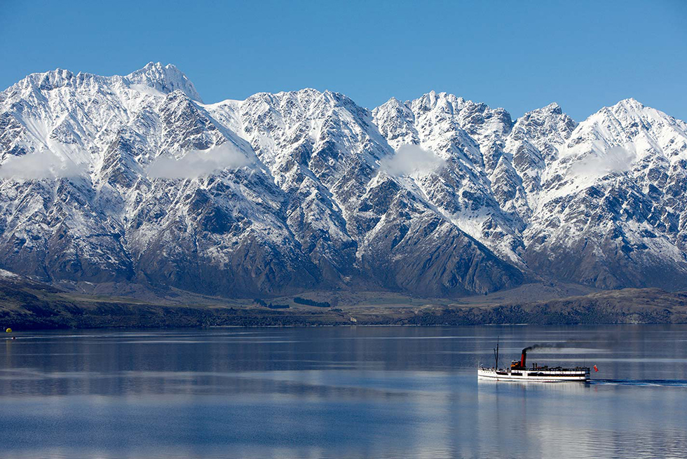Snowcovered mountains behind lake